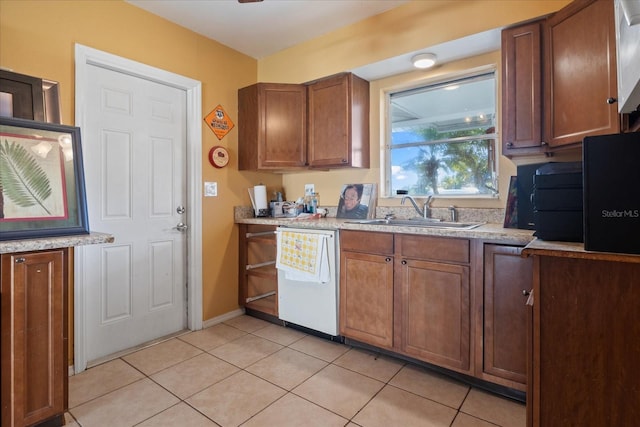 kitchen featuring light tile patterned flooring, white dishwasher, and sink