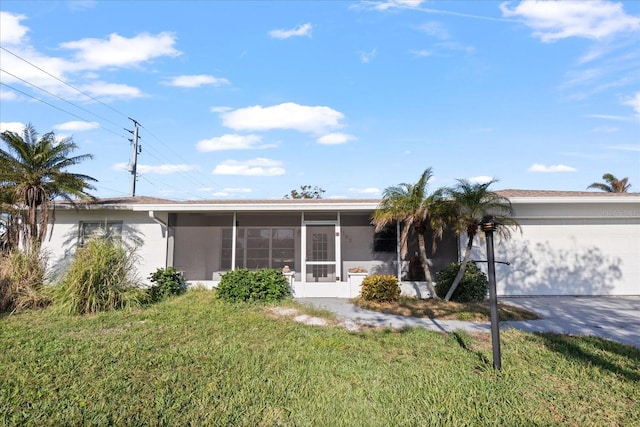 single story home with a garage, a front yard, and a sunroom