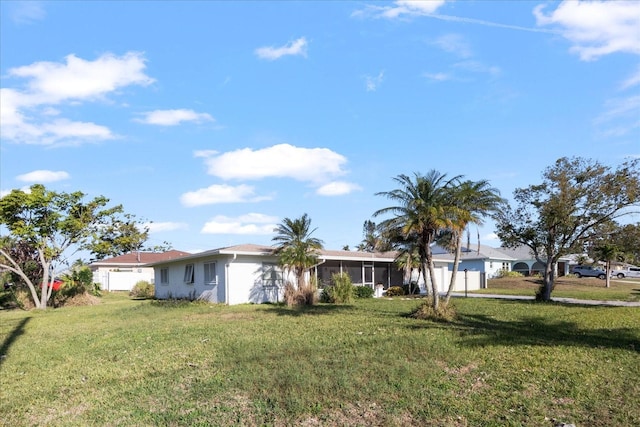 view of front of home featuring a front lawn and a sunroom