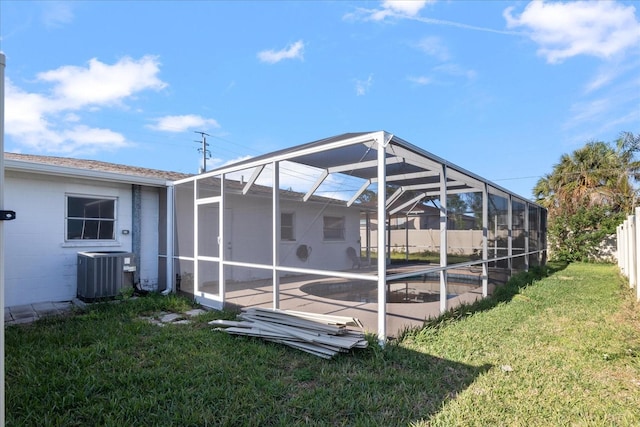 exterior space featuring central AC unit, a lanai, a patio, and a yard