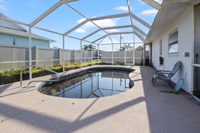 view of pool with a patio and glass enclosure