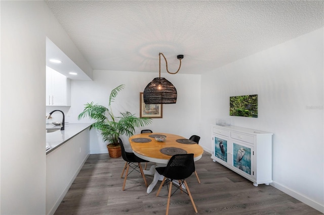 dining area featuring recessed lighting, a textured ceiling, baseboards, and wood finished floors