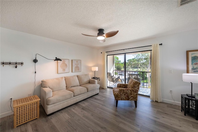 living room with visible vents, ceiling fan, a textured ceiling, wood finished floors, and baseboards