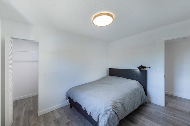 bedroom with wood finished floors and baseboards