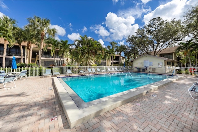 community pool with fence and a patio