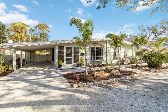 view of front of home with an attached carport and decorative driveway