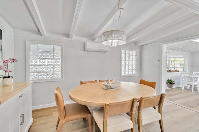 dining room featuring an AC wall unit, beamed ceiling, light wood-style flooring, and an inviting chandelier