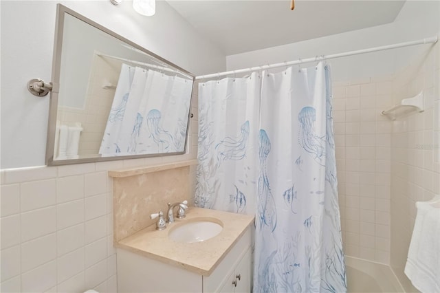 bathroom with shower / bathtub combination with curtain, tile walls, and vanity