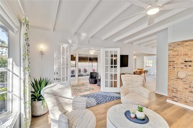 sunroom / solarium featuring french doors, ceiling fan, and beam ceiling