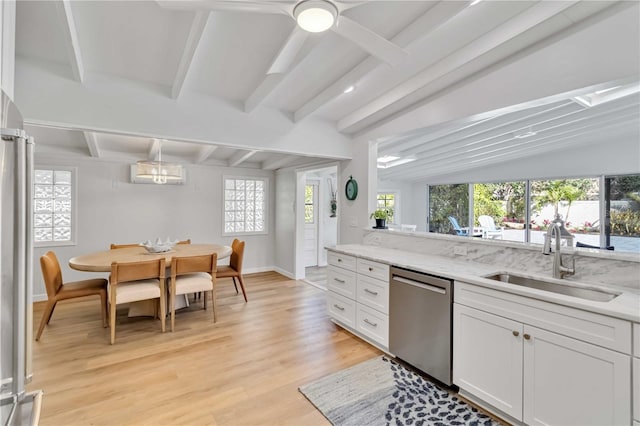 kitchen with stainless steel dishwasher, a sink, white cabinetry, and light stone countertops