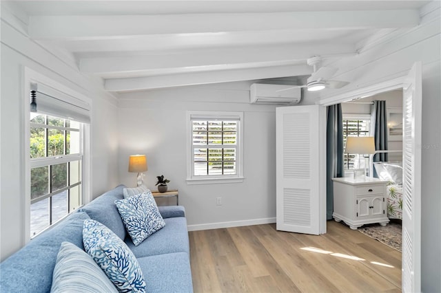 living room with light wood-style floors, a wealth of natural light, and a wall unit AC