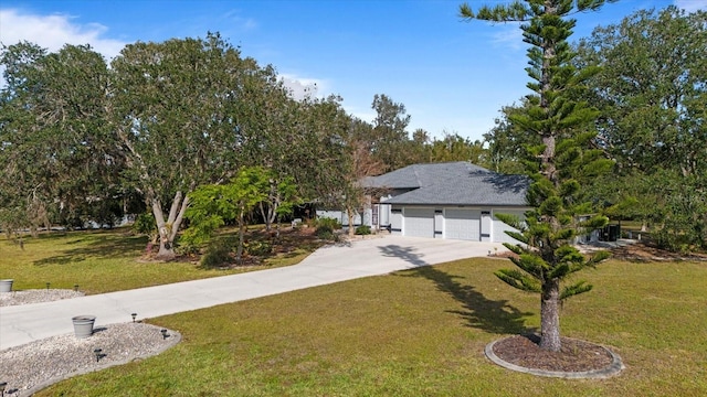 view of front of property featuring an attached garage, driveway, and a front yard