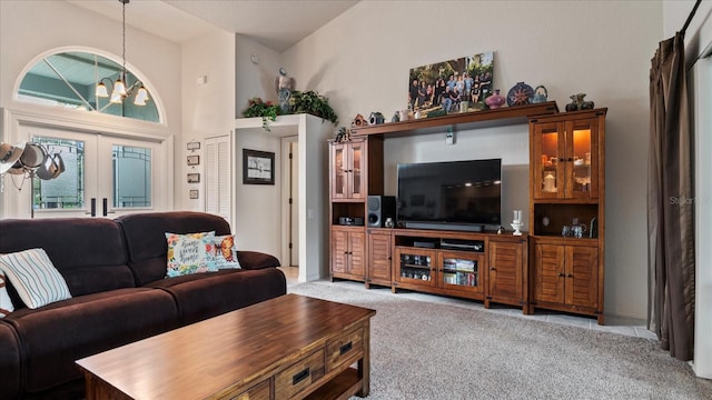 living room featuring french doors, a chandelier, and light carpet