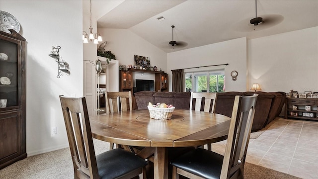 dining area featuring lofted ceiling, light carpet, and a chandelier