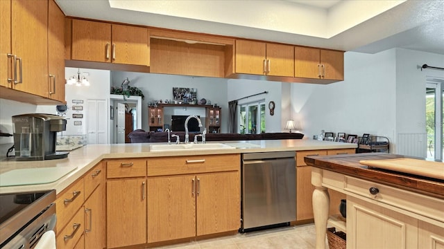 kitchen with sink, stainless steel appliances, kitchen peninsula, and light tile patterned flooring