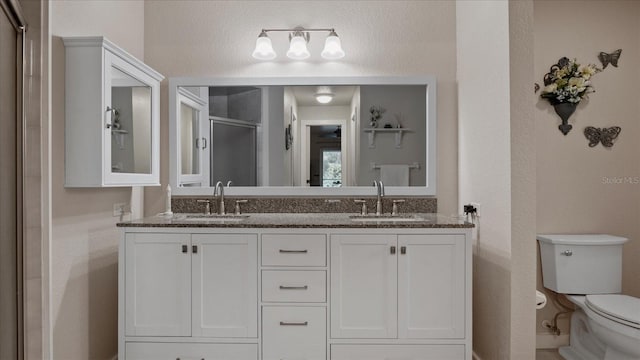 bathroom with vanity, toilet, and walk in shower