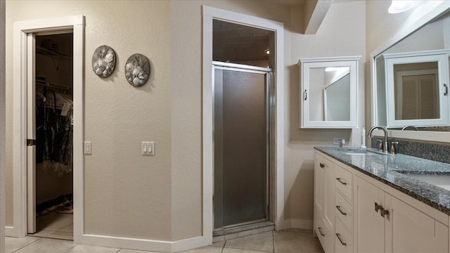 bathroom featuring vanity, tile patterned floors, and a shower with shower door