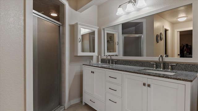 bathroom featuring a shower with door and vanity