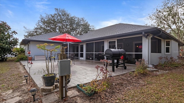 rear view of house featuring a patio and a sunroom