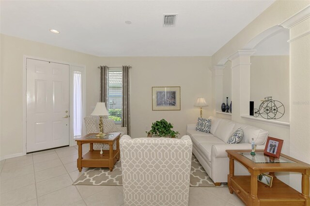 living room with light tile patterned floors and decorative columns