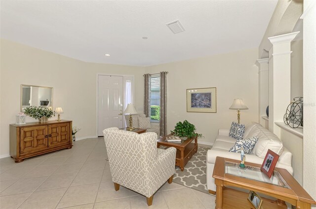 living room with ornate columns and light tile patterned flooring