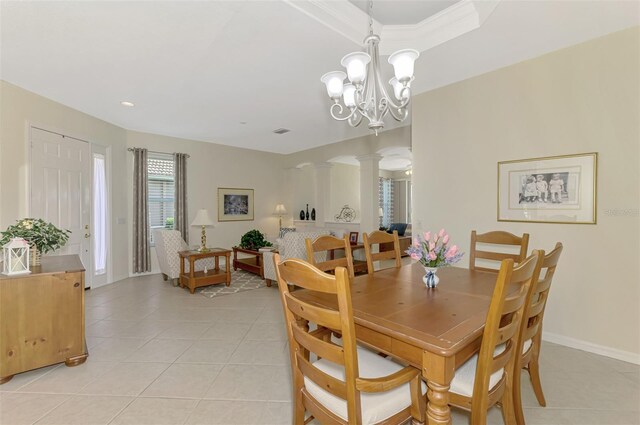 dining area featuring an inviting chandelier, light tile patterned floors, and decorative columns