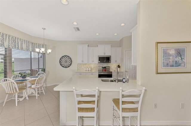 kitchen with white cabinets, a kitchen breakfast bar, hanging light fixtures, kitchen peninsula, and stainless steel appliances