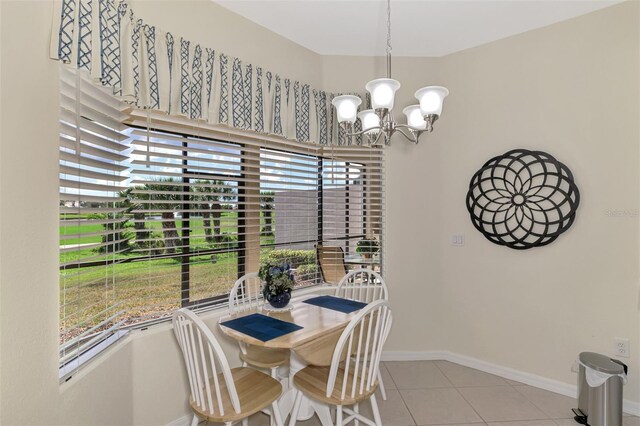 dining area featuring light tile patterned floors and an inviting chandelier