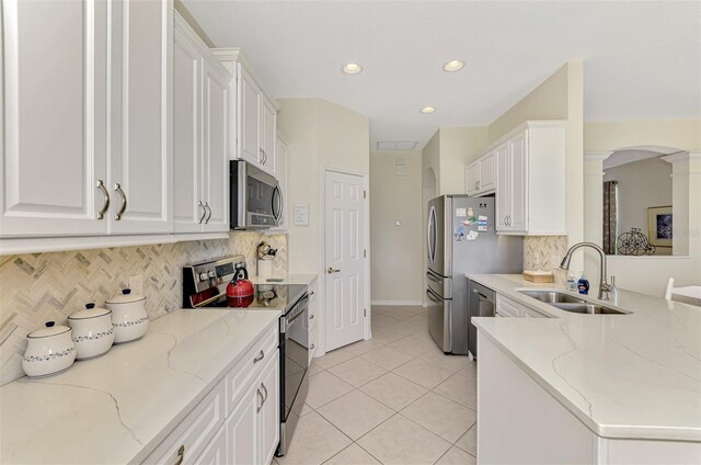 kitchen featuring light stone counters, sink, white cabinets, and appliances with stainless steel finishes