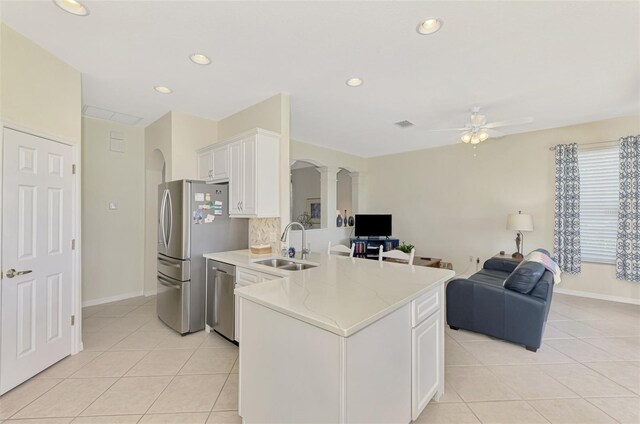 kitchen featuring light tile patterned flooring, appliances with stainless steel finishes, white cabinetry, sink, and kitchen peninsula