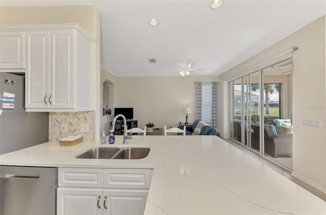 kitchen with sink, white cabinetry, light stone counters, dishwasher, and decorative backsplash