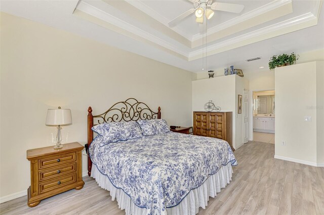 bedroom with ornamental molding, a raised ceiling, and light wood-type flooring