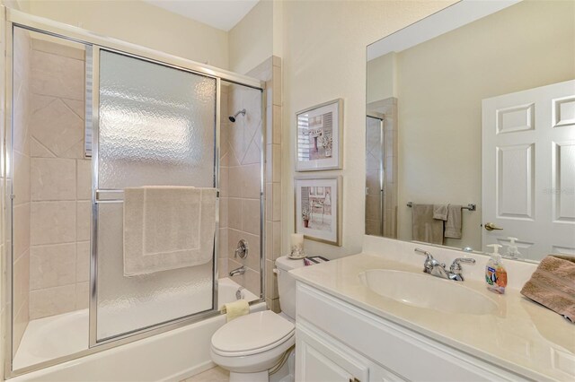 full bathroom with toilet, vanity, and bath / shower combo with glass door