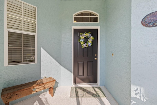 doorway to property featuring stucco siding