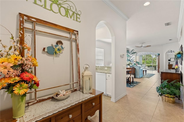 corridor with light tile patterned floors, visible vents, arched walkways, ornamental molding, and recessed lighting