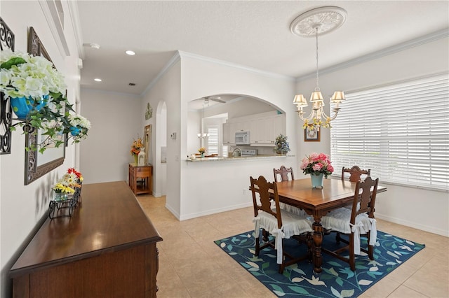 dining area featuring arched walkways, ornamental molding, light tile patterned flooring, and baseboards