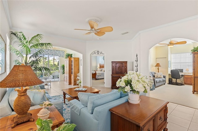 living room featuring a ceiling fan, arched walkways, visible vents, and ornamental molding