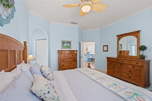 bedroom with multiple closets, a ceiling fan, visible vents, and crown molding