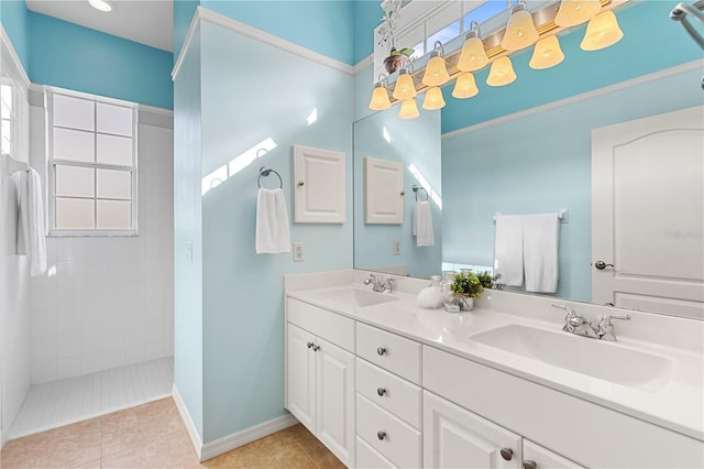 full bathroom with double vanity, baseboards, a walk in shower, and a sink