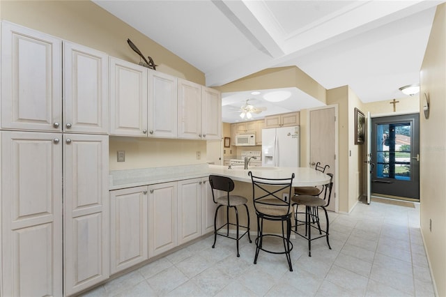 kitchen featuring vaulted ceiling with beams, a kitchen bar, ceiling fan, kitchen peninsula, and white appliances