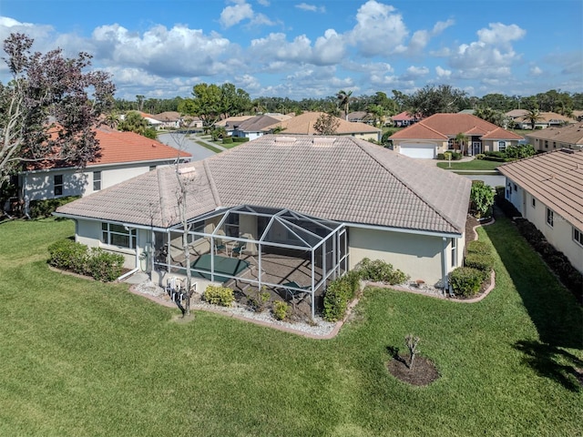 back of property with a lanai and a lawn