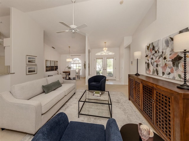 living room featuring light carpet, ceiling fan with notable chandelier, high vaulted ceiling, and french doors