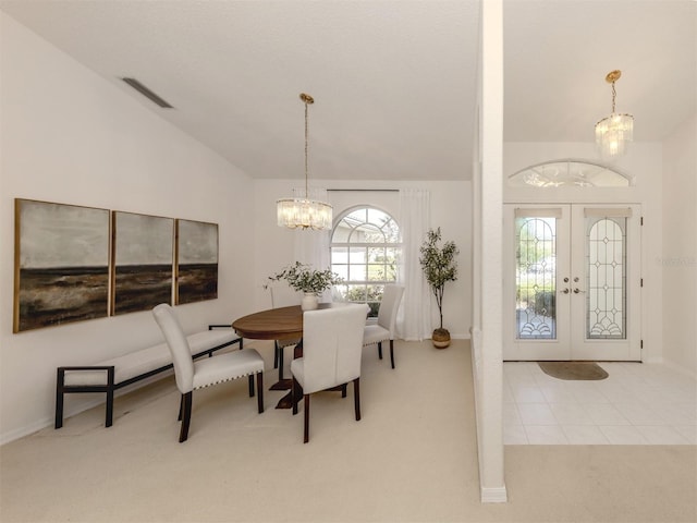 dining area featuring lofted ceiling, light colored carpet, an inviting chandelier, and french doors