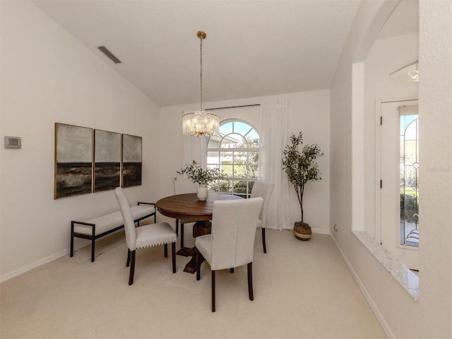 dining room with vaulted ceiling, plenty of natural light, and carpet floors