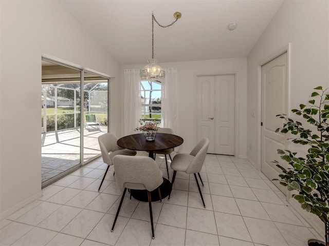 tiled dining room featuring vaulted ceiling and a chandelier