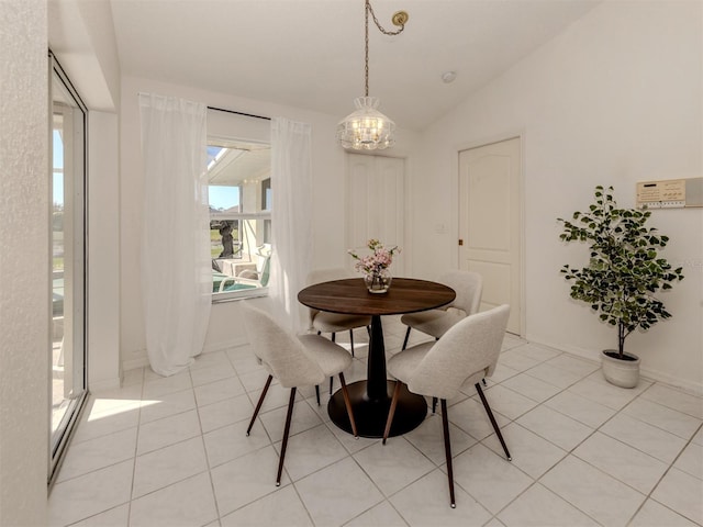 dining room featuring vaulted ceiling, light tile patterned floors, and an inviting chandelier