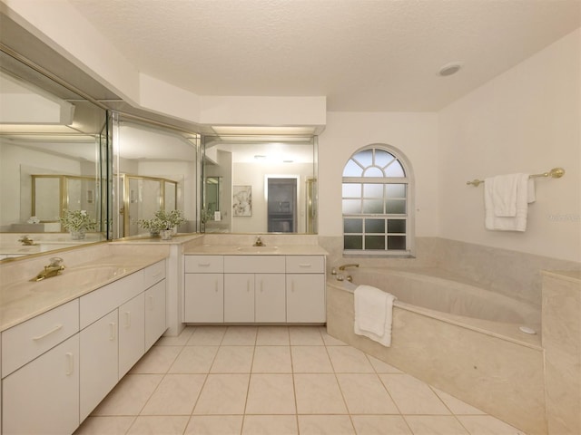 bathroom with shower with separate bathtub, tile patterned floors, a textured ceiling, and vanity