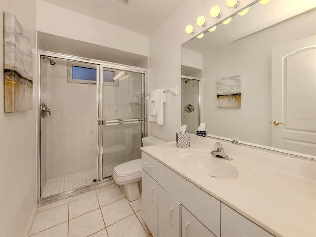 bathroom with a shower with door, vanity, tile patterned flooring, and toilet