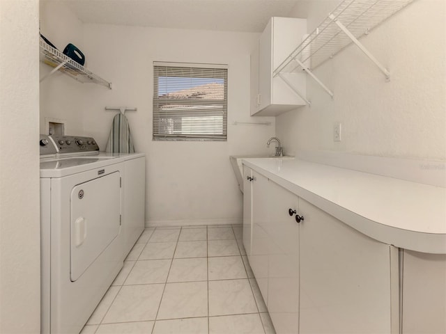 clothes washing area featuring cabinets, washer and clothes dryer, sink, and light tile patterned floors