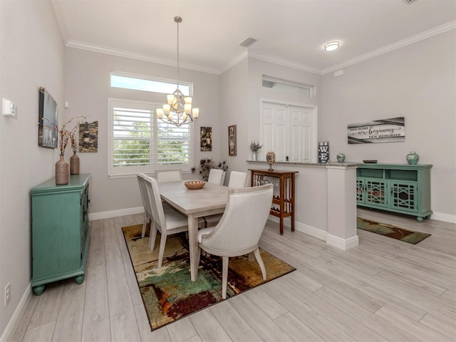 dining space featuring light wood-type flooring, baseboards, visible vents, and crown molding